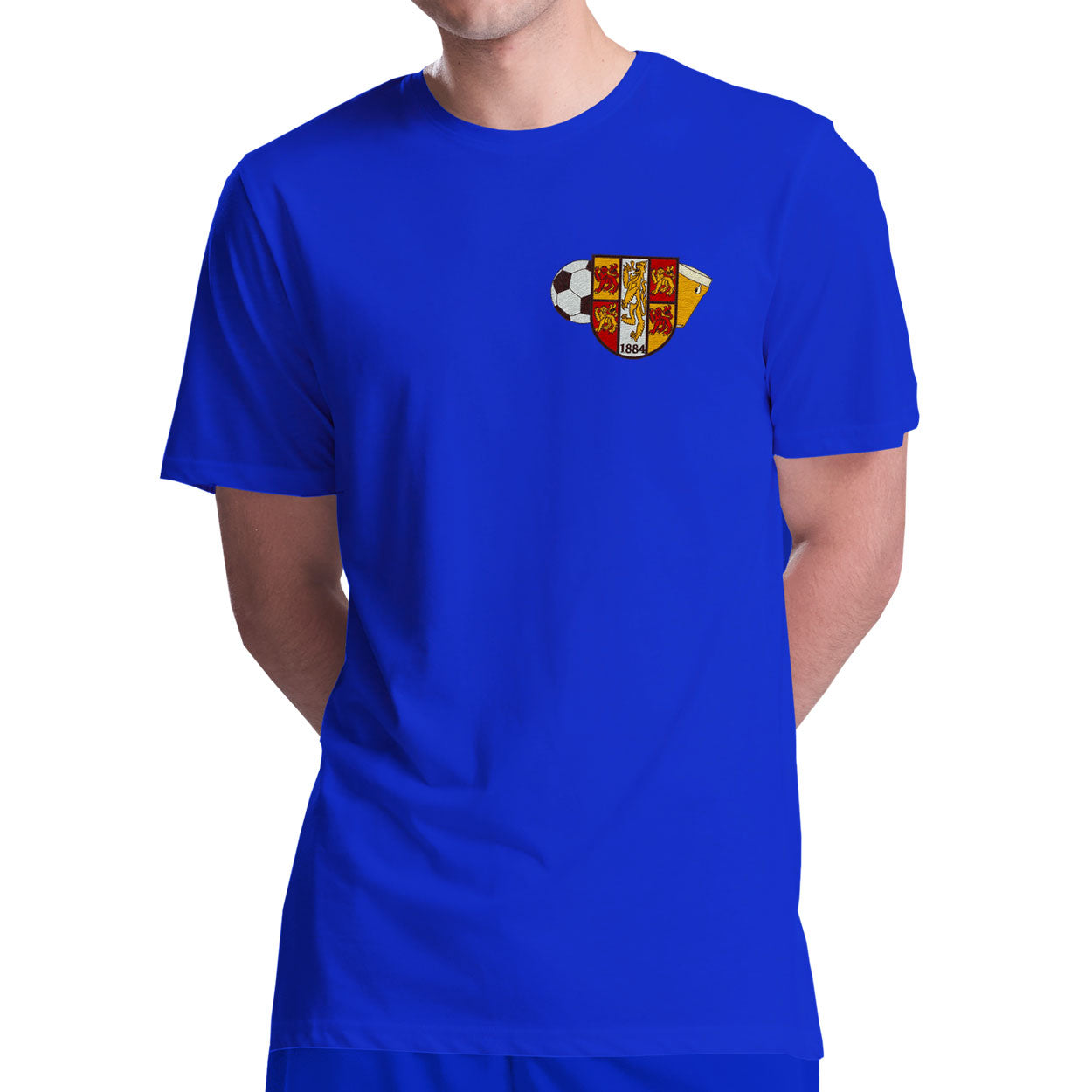 A man modeling a royal blue short sleeve football shirt and matching shorts set. The shirt features a Bangor Old Boys logo on the left breast.